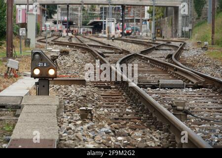 Ferrovia che conduce a Locarno in Svizzera con più shunt ferroviari che si divergono in diverse piste ferroviarie separate. In background ci sono piattaforme. Foto Stock