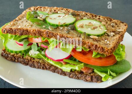 Panini sani fatti in casa con verdure e salmone affumicato. Colazione gustosa e concetto di cibo sano. Foto Stock