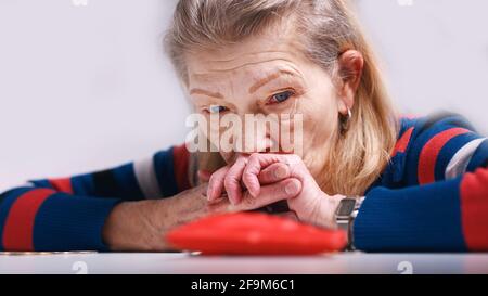 donna anziana senza speranza che guarda il portafoglio vuoto. Foto di alta qualità Foto Stock