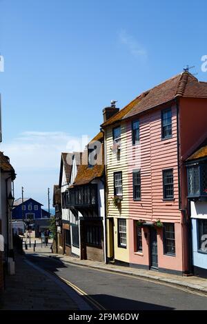 Caratteristiche storiche case in legno in All Saints Street nel centro storico, guardando verso la costa (mare appena visibile in distanza), Hastings, East Sussex, Regno Unito Foto Stock