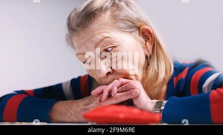 donna anziana senza speranza che guarda il portafoglio vuoto. Foto di alta qualità Foto Stock