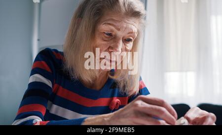 Persona anziana che mette i soldi nel suo portafoglio. Donna povera che sta esaurendo i soldi. Foto di alta qualità Foto Stock