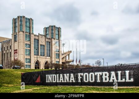 03 26 2021 Bloomington USA - Stadio Hoosier dell'Università dell'Indiana con bandiere a metà albero sotto il cielo nuvoloso e segno - Indiana Football - in foregroun Foto Stock