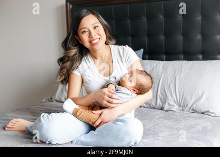 Festa della mamma. Sorridente madre cinese asiatica con neonato. Foto Stock