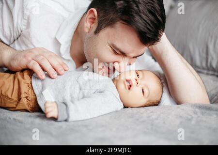 Closeup di felice papà sorridente padre baciare neonato bambino figlio ragazzo. Foto Stock