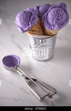 tre gelati al mirtillo su marmo bianco in contenitore metallico Foto Stock