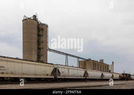 KINGSPORT, TN, USA--8 APRILE Train Tracks, con macchine tramoggia di grano che si trovano davanti a più silos. Foto Stock
