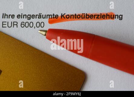 Dresda, Germania. 19 Apr 2021. Una penna a sfera e una carta di credito si trovano su un estratto conto bancario che recita "il tuo importo di 600.00 euro concesso in eccesso". Un uomo è stato accusato di ingannare le banche dal denaro come un cosiddetto 'corridore'. La truffa coinvolge i truffatori che aprono i conti bancari con i documenti falsi e poi maxing verso l'esterno la funzione di overdraft. (To dpa 'Fraud trial about 'Runner' truffa') Credit: Robert Michael/dpa-Zentralbild/dpa/Alamy Live News Foto Stock