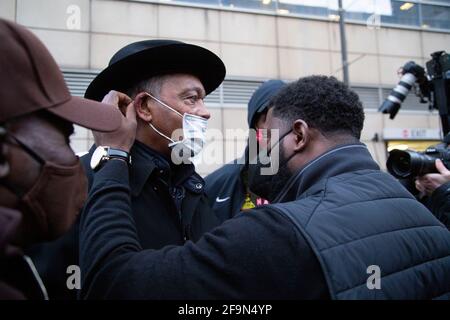 Minneapolis, Minnesota, Stati Uniti. 19 Apr 2021. 19 aprile 2021-Minneapolis, Minnesota, USA: Una persona aiuta il reverendo Jesse Jackson a mettere la sua maschera poco dopo aver parlato. Più di 400 dimostranti hanno marciato attraverso il centro di Minneapolis poco dopo la conclusione degli argomenti di chiusura nel processo di Derek Chauvin. Chauvin, di Oakdale, Minnesota, è stato processato per l'assassinio di George Floyd mentre in servizio come ufficiale di polizia di Minneapolis il 25 maggio 2020. Credit: Henry Pan/ZUMA Wire/Alamy Live News Foto Stock