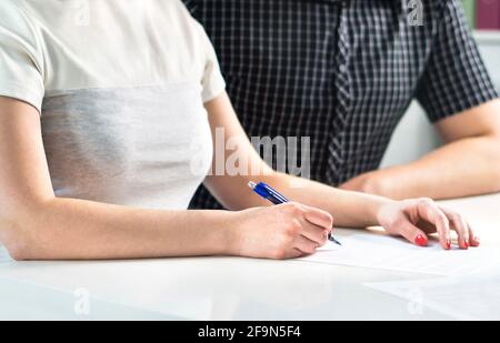 Coppia che scrive un programma, contando il preventivo della famiglia o firmando il contratto di liquidazione. Moglie e marito che fanno la lista di controllo, organizzazione futura insieme. Foto Stock