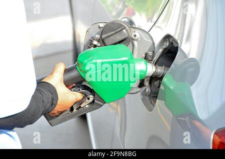 Un uomo che riempie il serbatoio del gas di un'auto Foto Stock