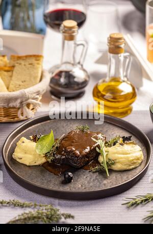 Manzo al barbecue affumicato con salsa barbecue servita con purè patate sul tavolo del ristorante Foto Stock