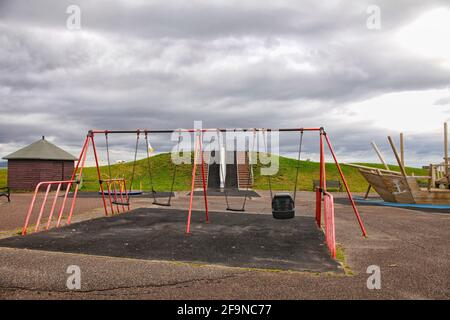 Vuoto parco giochi con altalena sul lungomare in Scozia Foto Stock