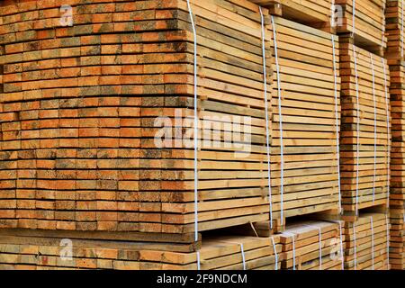 Le tavole di legno sono impilate in pile nell'officina. Background industriale, legname per imprese. Legname di pino per la produzione e la costruzione di mobili. Foto Stock