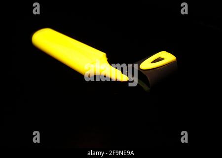 Pennarello giallo e cappuccio isolati in primo piano nero Foto Stock