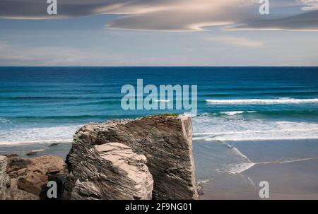 Vista di Playa de las Catedrales a Ribadeo, Galizia, con il mare sullo sfondo e il cielo nuvoloso. Foto Stock