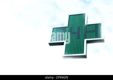 Croce verde della farmacia che indica 24 ore di apertura. Nessuna gente Foto Stock