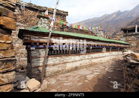 Preghiera buddista molti muri con ruote di preghiera nel villaggio nepalese, percorso Annapurna circuito trekking, Nepal Foto Stock