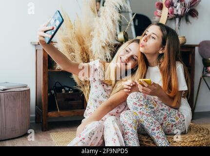 Due sorelle adolescenti prendono un selfie al telefono. Foto Stock