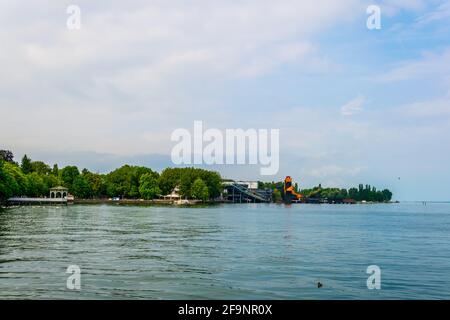 Un teatro all'aperto di colore arancione situato al centro di una striscia verde di alberi che circondano il lago bodensee, vicino a Bregenz, in Austria. Foto Stock