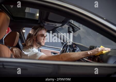 Uomo seduto sul cruscotto del tergicristallo Foto Stock