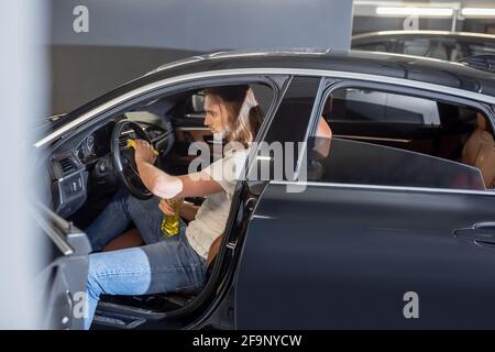 Uomo seduto sul sedile anteriore della pulizia dell'auto Foto Stock