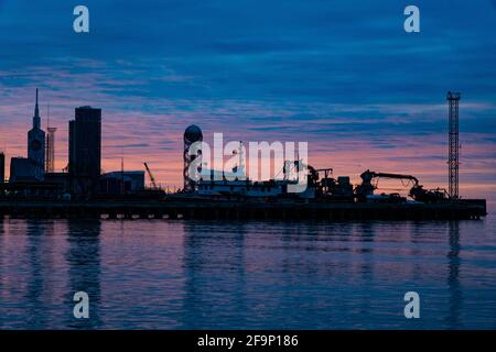 Tramonto arancione-blu sullo sfondo della città Foto Stock