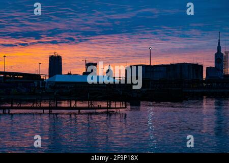 Tramonto arancione-blu sullo sfondo della città Foto Stock