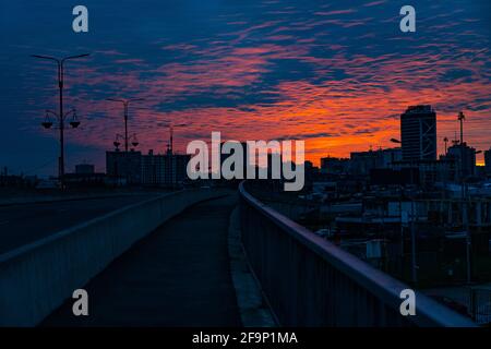 Tramonto arancione-blu sullo sfondo della città Foto Stock