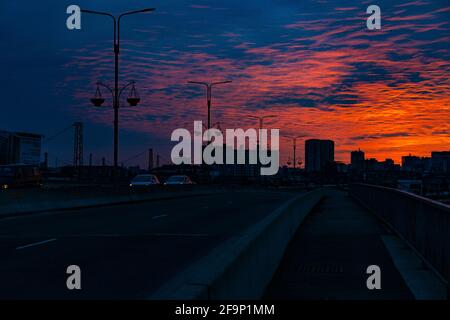 Tramonto arancione-blu sullo sfondo della città Foto Stock