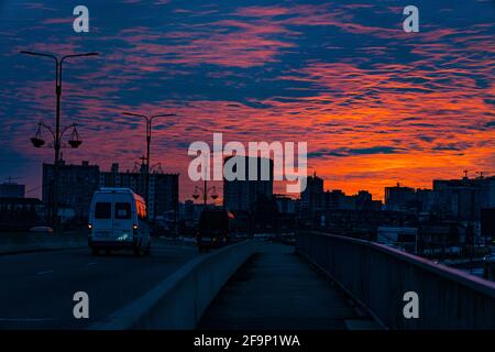 Tramonto arancione-blu sullo sfondo della città Foto Stock