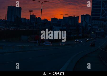 Tramonto arancione-blu sullo sfondo della città Foto Stock