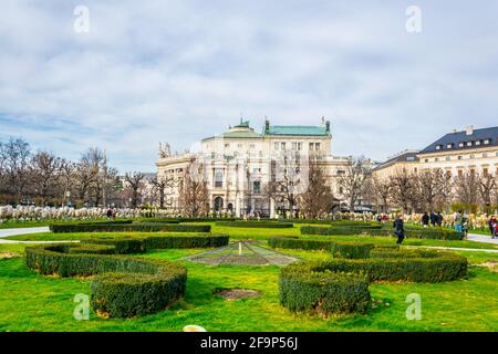 Splendida vista del famoso parco pubblico Volksgarten (Giardino del Popolo) con lo storico Burgtheater sullo sfondo a Vienna, Austria. Foto Stock