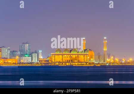 Al Fateh Grande moschea che si riflette sul mare durante il tramonto Foto Stock