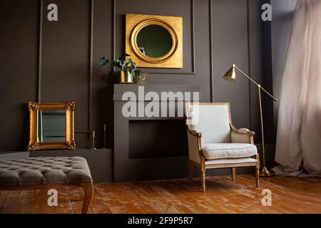 Foto reale di un divano grigio in piedi in un elegante salotto interno  dietro un tavolo bianco con foglie e di fronte a un muro grigio con poster  Foto stock - Alamy