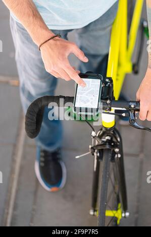 Uomo che consulta la mappa con un'app per conoscere i luoghi e fare consegne con la bicicletta. Foto Stock