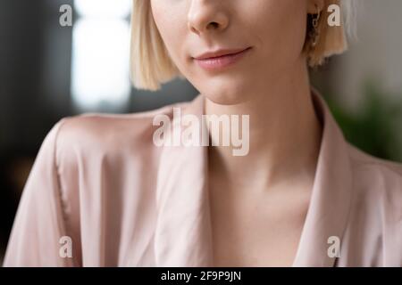 Primo piano di giovane donna con capelli biondi corti in elegante giacca Foto Stock
