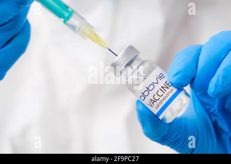 Vaccino Abbvie contro il coronavirus raccolto nella siringa da operatore sanitario o medico in guanti protettivi e tuta PPE, aprile 2021, San Francisco Foto Stock
