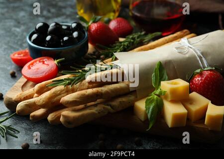 Grissini, spuntini e vino su sfondo nero fumé Foto Stock