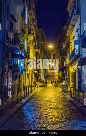 vista notturna della strada illuminata che conduce attraverso il centro storico della città italiana napoli - napoli. Foto Stock