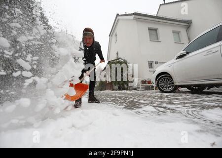 07.02.2021, Berlin, , Germania - uomo che tesse la neve appena caduta dal marciapiede di fronte alla sua proprietà. 00S210207D478CAROEX.JPG [MODELLO RELEA Foto Stock