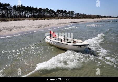 20 aprile 2021, Meclemburgo-Pomerania occidentale, Zingst: La spiaggia della località Baltica è quasi deserta, mentre una barca di pescatore è ancorata alla spiaggia. Un inizio della stagione non è prevedibile dopo il blocco serrato. Il festival fotografico ambientale "horizonte zingst", in programma dal 28 maggio al 06 giugno 2021, è stato annullato. Tuttavia, le mostre sono tutte da allestire e possono essere viste fino all'autunno. Foto: Bernd Wüstneck/dpa-Zentralbild/ZB Foto Stock