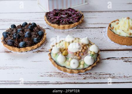 Torta con pasticceria e crema di pistacchio. Decorato con meringa, pistacchio con vernice dorata, croccanti di cioccolato bianco e caramello salato. Foto Stock