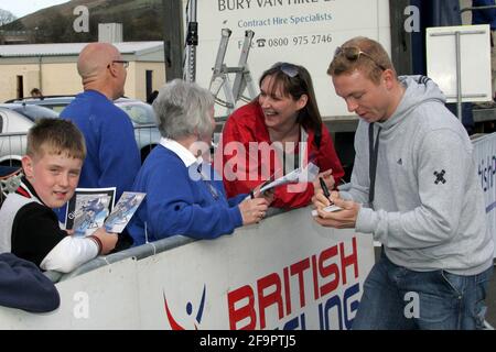 Girvan, Ayrshire, Scozia. REGNO UNITO. Il vincitore della medaglia Multi World e Olympic Chris Hoy, che aveva trascorso il pomeriggio divertendo il grande gruppo di giovani piloti iscritti alla gara inaugurale del circuito Scozzese dei giovani rinnovabili, disputata sullo stesso circuito. Foto di Chris Hoy che interagisce con i ciclisti Foto Stock