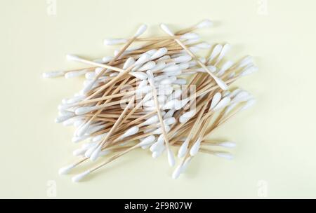 Mucchio di bastoncini di cotone di bambù o gemme vista dall'alto su sfondo beige, spazio copia Foto Stock