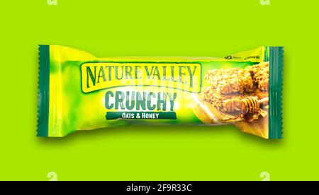 SWINDON, UK - 20 APRILE 2021: Nature Valley Crunchy Oats e Honey bar su sfondo verde. Foto Stock