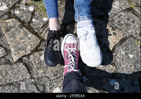In piedi hipster con sneakers e scarpe da ginnastica su cemento. Gambe in  vecchie sneakers rosse su erba verde. Vista dall'alto. Il concetto di  gioventù, primavera Foto stock - Alamy