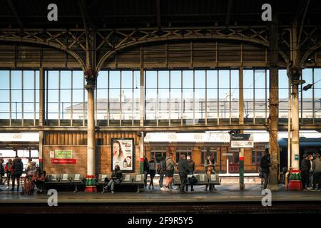 Persone che indossano maschere in attesa del treno alla stazione ferroviaria di Preston, Lancashire, Regno Unito. Foto Stock