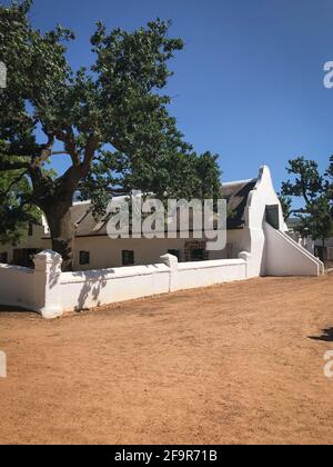 Edificio storico in stile architettonico capo olandese presso la fattoria Babylonstoren vicino Paarl, Sud Africa, contro il cielo blu Foto Stock