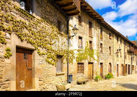 Vista sulla via del Colle Castell, una delle strade più tipiche del centro medievale di Rupit dove tutte le case hanno l'estetica dei mezzi Foto Stock